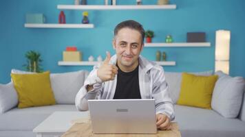 Man looking at laptop making positive gesture. video