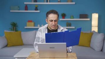 Man working on laptop throws files angrily. video