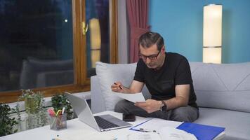 Home office worker man smiling at camera looking at paperwork. video