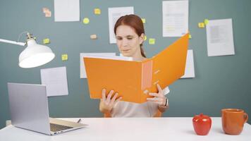 Woman working on laptop throws files angrily. video