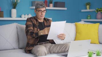 The old man looking at the papers rejoices. video