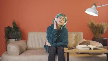 Young woman listening to music with headphones is unhappy and sad. video