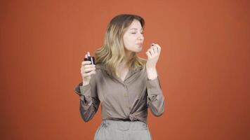 The young woman who puts on perfume and smells good. video