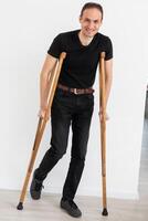 Young man with axillary crutches photo