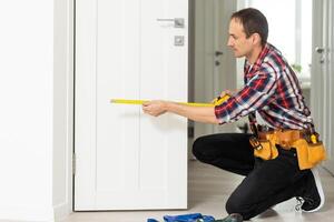 Master with screwdriver installs door hinges. photo