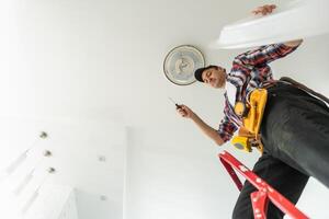 electrician installing led light bulbs in ceiling lamp photo