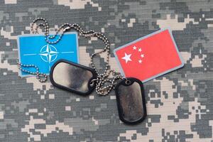 army blank, dog tag with flag of nato and vietnam on the khaki texture background. military concept. High photo