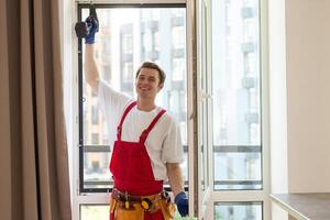 Construction worker installing window in house. photo