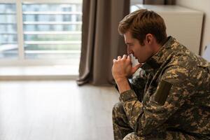 Thoughtful young handsome soldier in military uniform. photo