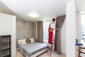 A male worker who installs a curtain. photo