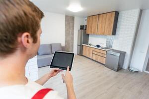 Worker with tablet computer checking alarm system indoors. photo