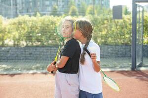 dos muchachas con bádminton raquetas en el fútbol americano campo. foto