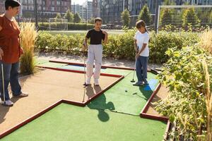 golfers with parents playing golf at sunny day photo