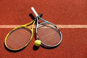 Close up view of tennis racket and balls on the clay tennis court photo