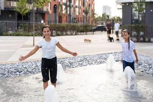 en un caliente día, niños correr y tener divertido a el ciudad fuente. ocio hora concepto. verano vacaciones. contento infancia. foto