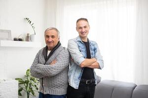 Portrait of happy smiling father and his adult son. Man hugging his elderly father. Father's day concept. photo