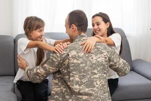 Little children hugging their military father at home photo