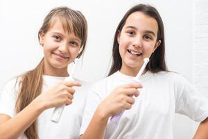 Funny portrait of a young girls brushing photo