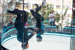 joven hombre disfrutando volador en un aerodinámico túnel. foto