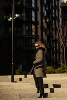 The girl in a coat walks around the city on a sunny day photo