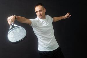 Paddle tennis player ready for serve on gray background photo