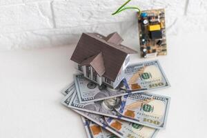 House standing on a pile of dollar bills. Investment, real estate and property concept photo