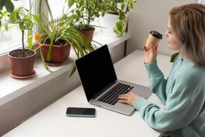 woman with laptop and takeaway coffee photo