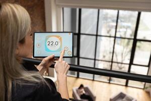 Woman at home using smart screen, automation domestic system photo
