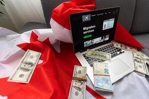 laptop with migration service and Canadian flag photo