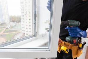 Man in a shirt does window installation photo