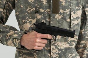 militar hombre participación un pistola en mano foto
