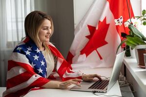 Positive teacher in headset having online lesson on laptop near globe and flags in school photo