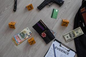 concepto de investigación de la escena del crimen: pistola y proyectil de bala contra el marcador amarillo del crimen en el piso del apartamento foto
