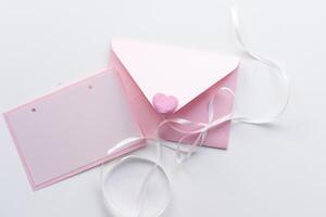 Flat lay on a soft pink background envelope with hearts. Valentine's day and wedding concept. Declaration of love photo