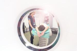 Radiologist with a female patient in the room of computed tomography. photo