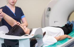 Radiologic technician and Patient being scanned and diagnosed on computed tomography scanner in hospital photo