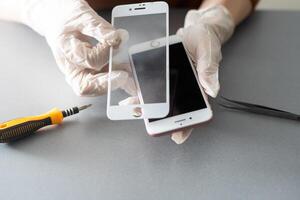 Technician prepairing to repair and replace new screen broken and cracked screen smartphone prepairing on desk. photo