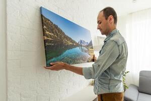 a man is holding a photo canvas