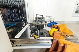 dishwasher door removed for repair, breakdown of kitchen appliances. photo