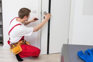 Young man fixing the door in house. photo