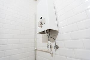 Broken Modern Water Gas Heater Next to Shower Cabin Inside Elegant Clean Bathroom Interior. photo