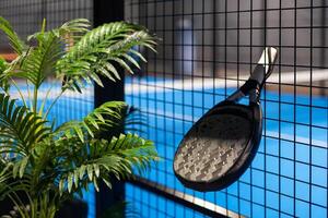 Paddle tennis. Paddel racket and ball in front of an outdoor court photo