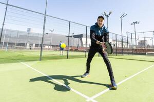 Man playing paddle tennis. Jumping and shooting the ball. photo