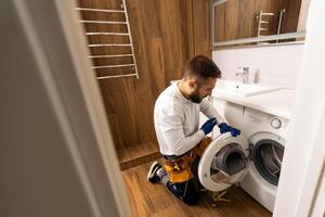 Professional plumber with plunger and instruments near sink. photo