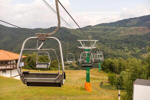 Mountain yellow lift on a summer day over the mountains. Old ski lift in the mountains in the sun. Carpathians, Ukraine. photo