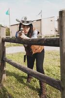 Portrait of a beautiful Chinese female cowgirl shooting with a weapon photo