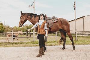 linda chino vaquera mientras tomando cuidado de su caballo foto