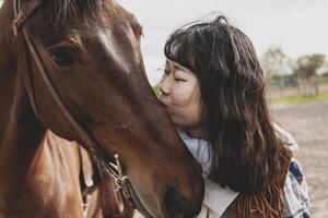 cute chinese cowgirl while taking care of her horse photo