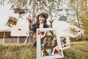 retrato de un hermosa chino hembra vaquera jugando con póker tarjetas foto