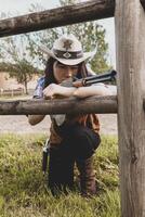 Portrait of a beautiful Chinese female cowgirl shooting with a weapon photo